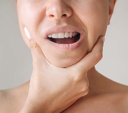 Woman holding her jaw Woman holding her jaw